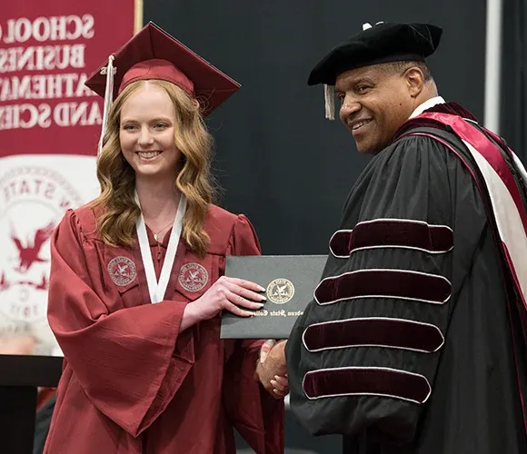 College president and graduate smiling